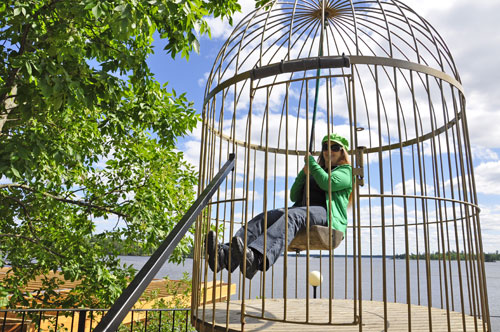 Karen Duquette in a large bird cage